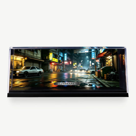 LUXEMARK Tokyo street artwork with illuminated storefronts and wet-road reflections in a clear display case