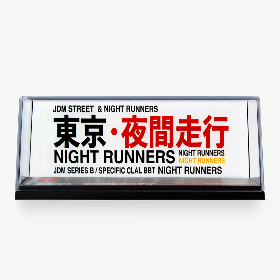 LUXEMARK Clear display case with a white Night Runners backdrop and bold black, red and yellow lettering